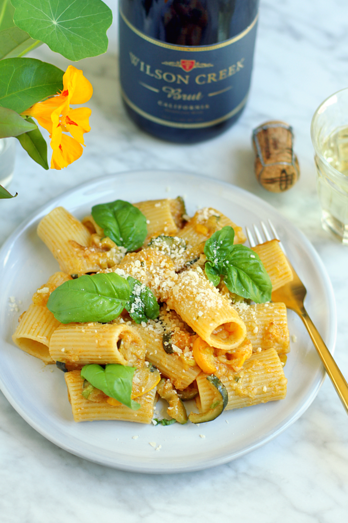 Close-up image of Wilson Creek Brut Sparkling Wine with summer squash and basil pasta.