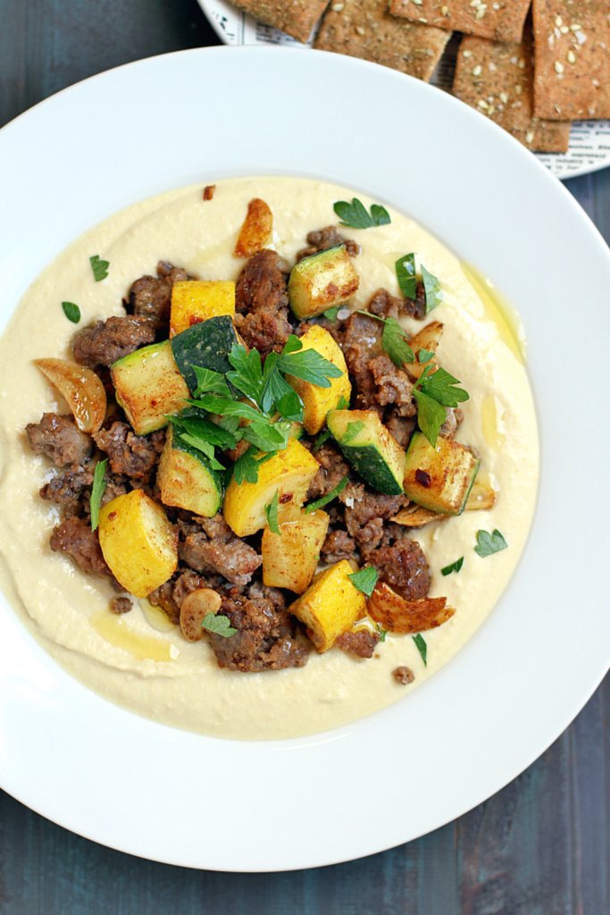 Close-up image of hummus with spiced lamb and summer squash.