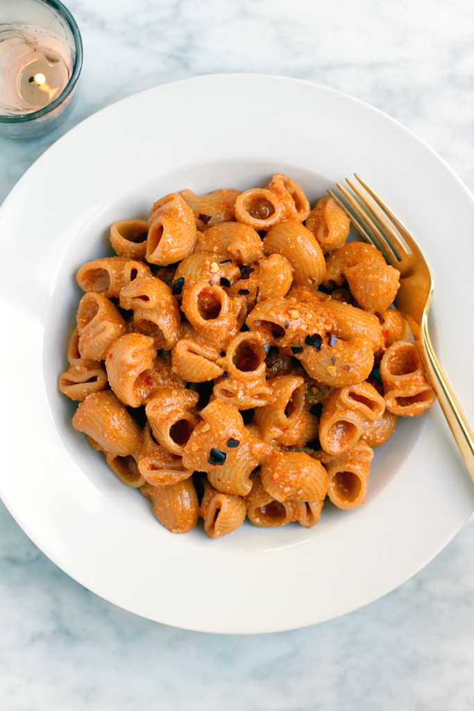 Close-up image of pasta with red pesto.