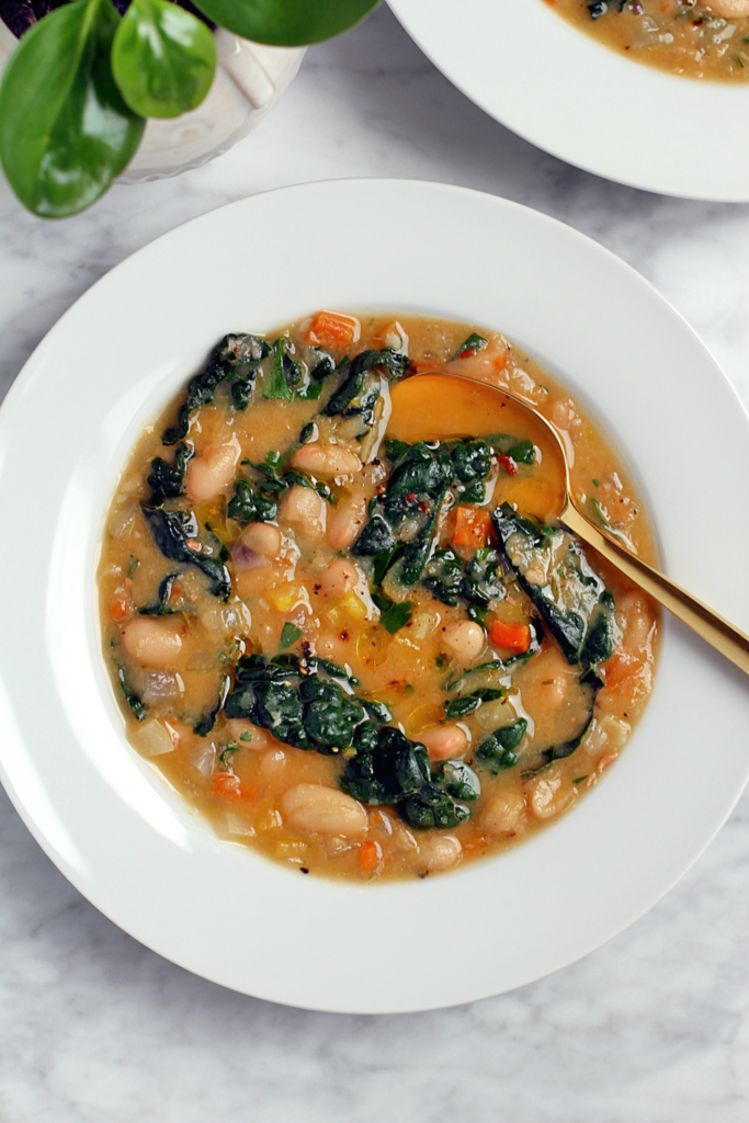 Close-up image of creamy white bean soup with kale.