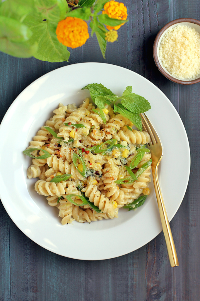 Close-up image of creamy corn pasta with mint.