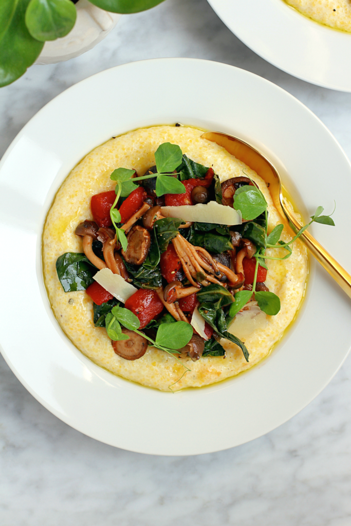 Close-up image of creamy polenta with collard greens and mushrooms.