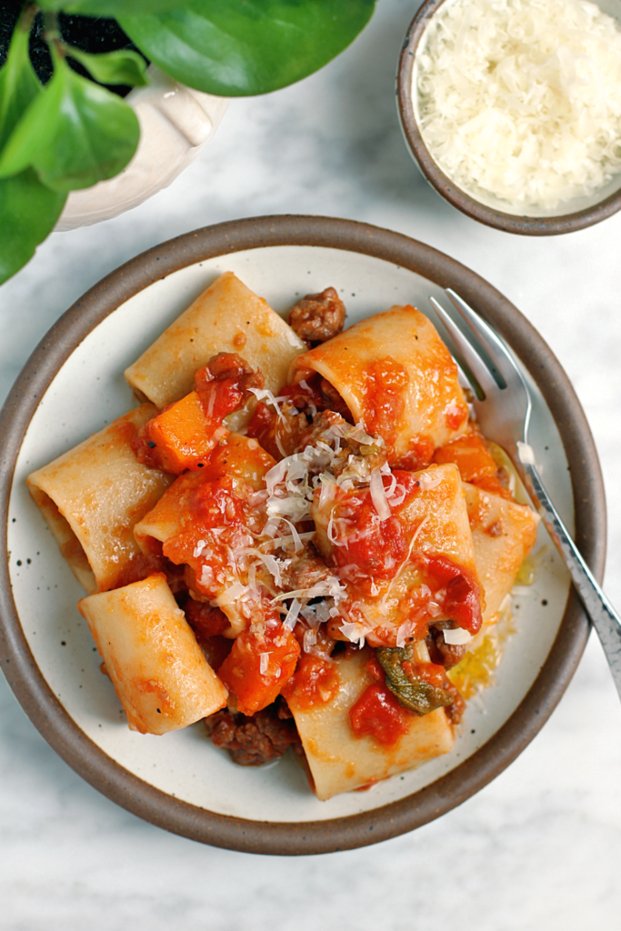 Close-up image of pasta with butternut squash and sausage ragù.