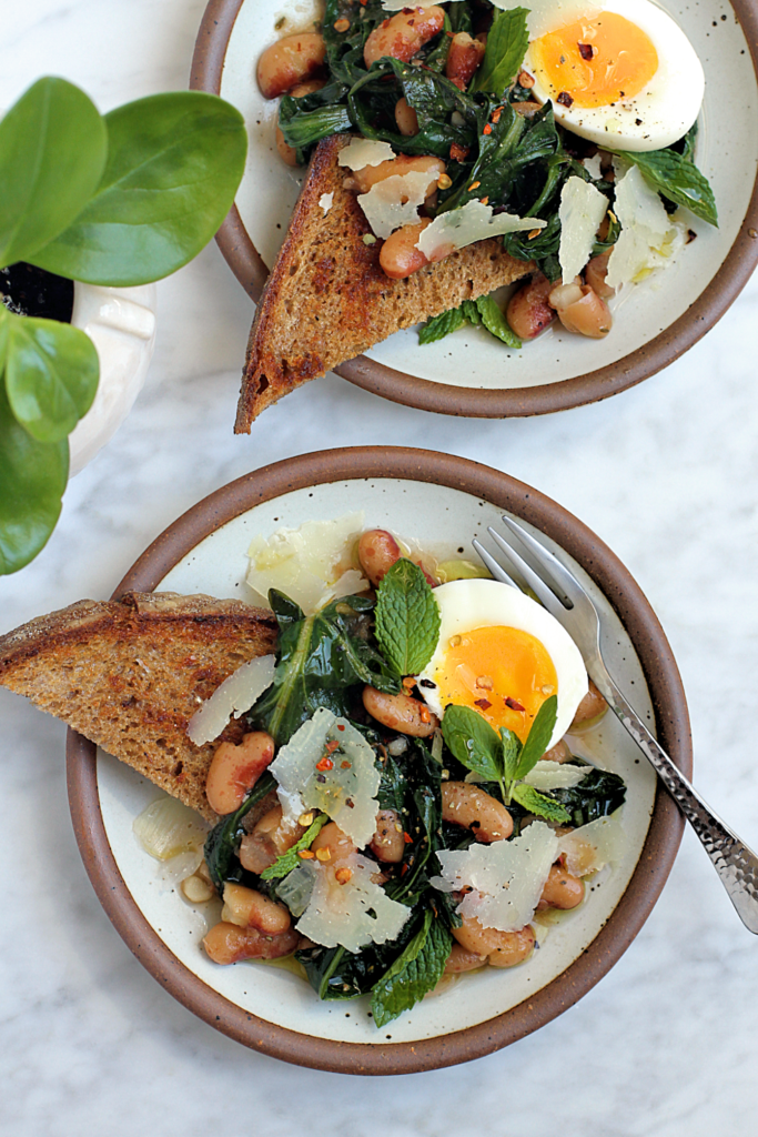 Image of brothy beans and greens on toast.