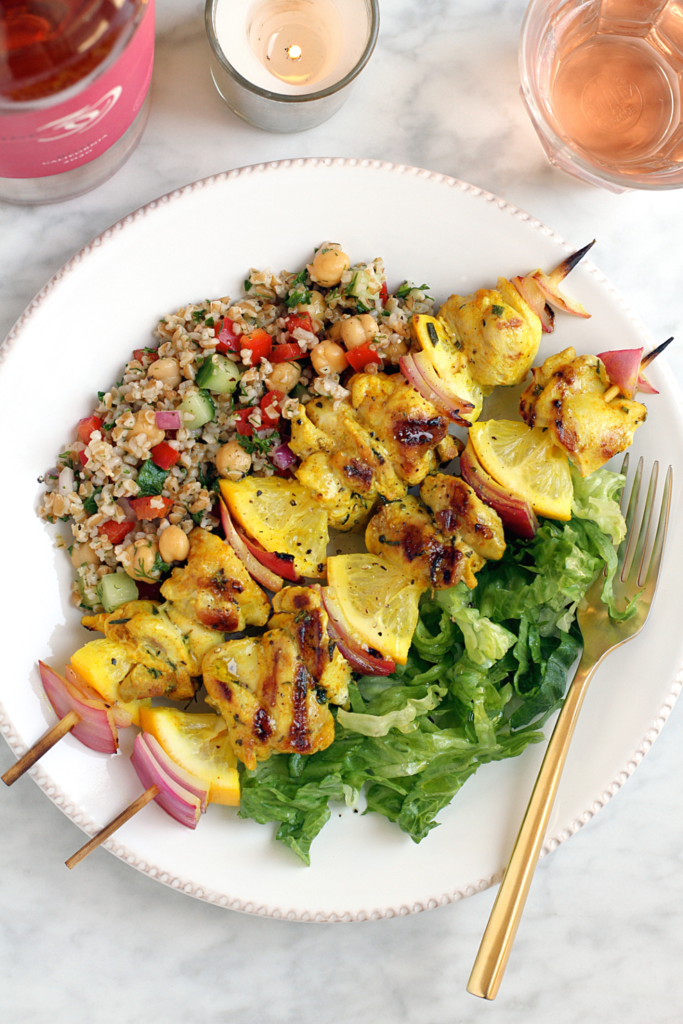 Close-up image of grilled lemon chicken kebabs with bulgur salad.