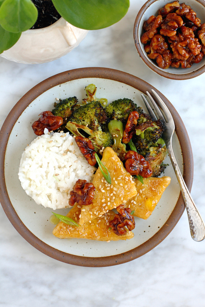 Close-up image of honey walnut tofu with sesame roasted broccoli.