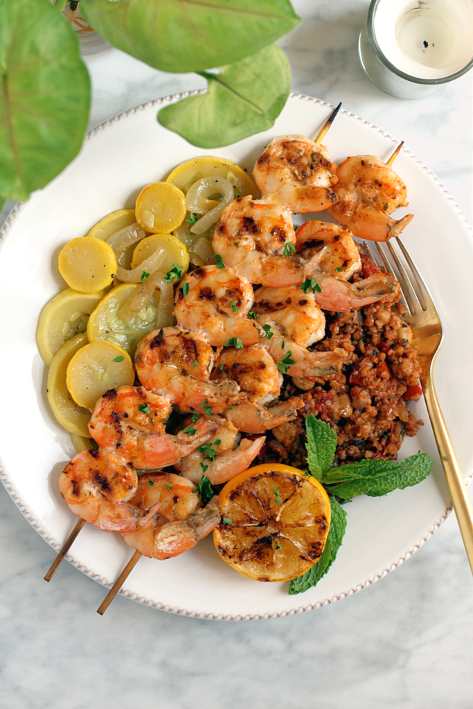 Close-up image of grilled shrimp skewers with Turkish bulgur pilaf.