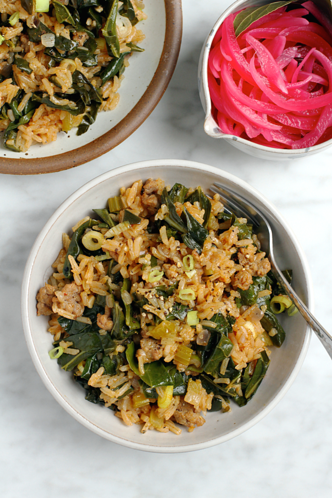 Close-up image of dirty rice with collard greens.