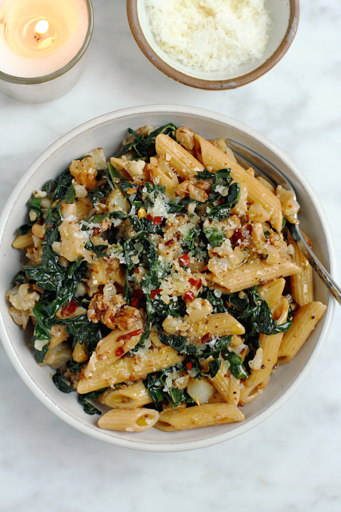 Close-up image of charred cauliflower and kale pasta.