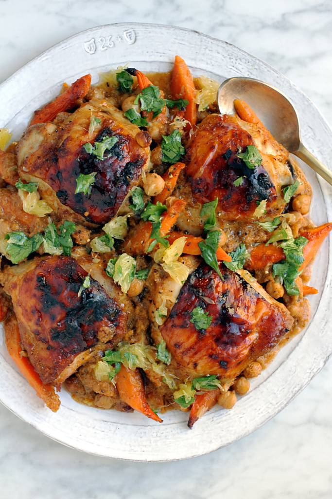 Close-up image of berbere spiced chicken, carrots and chickpeas.
