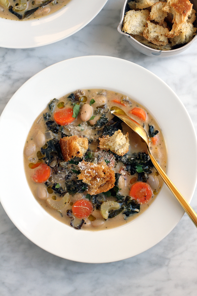 Close-up image of vegan white bean soup with kale.