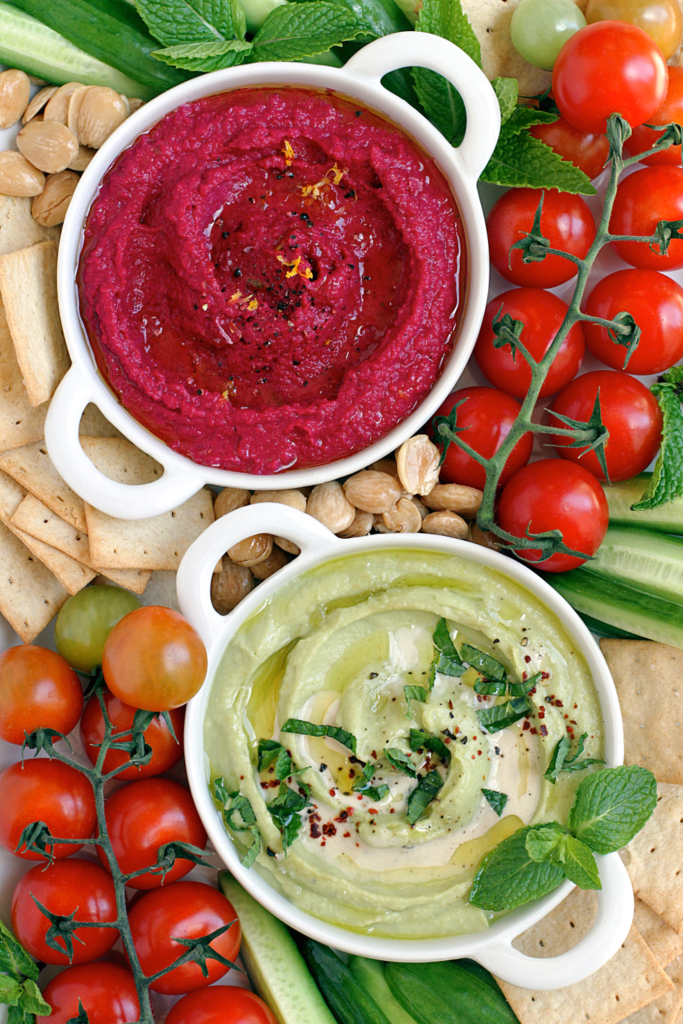 Close-up image of beet hummus and creamy avocado hummus.