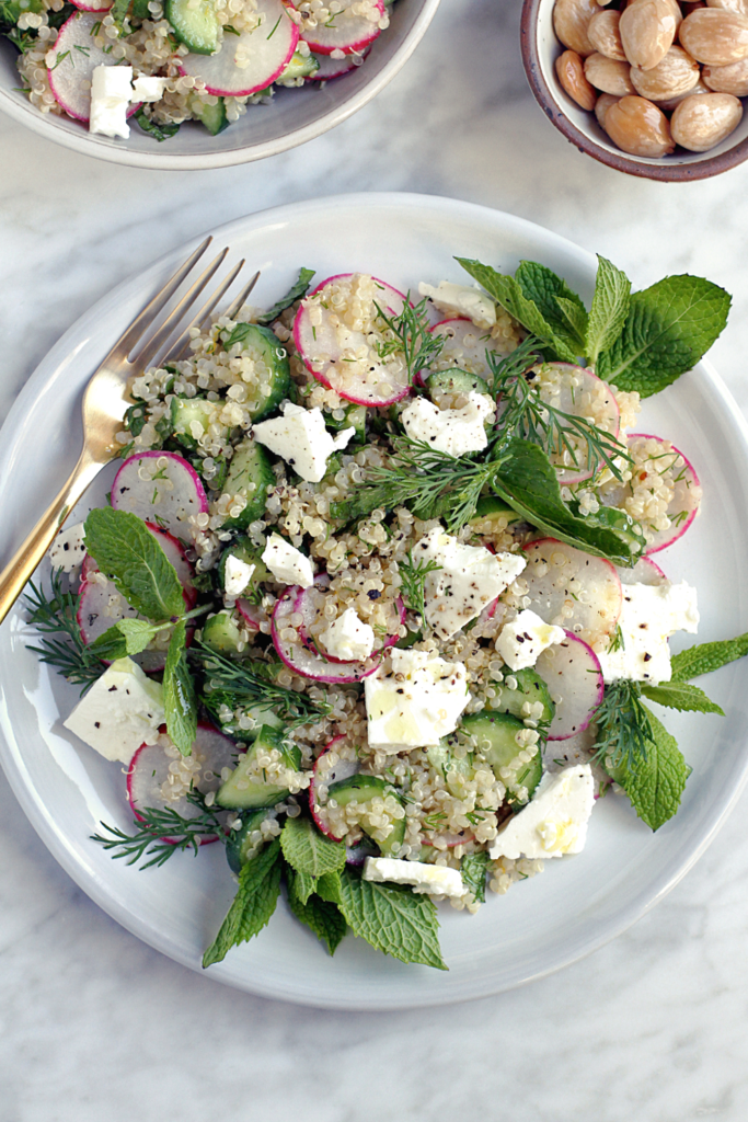 Close-up image of quinoa salad with cucumbers and radishes.