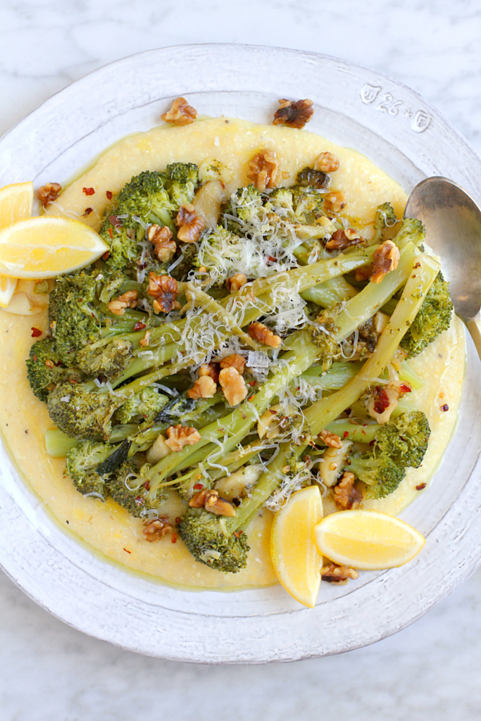 Close-up image of baked polenta with floppy broccoli.