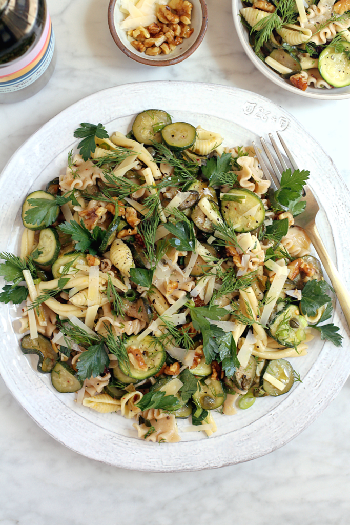 Image of pasta salad with zucchini and sizzled scallions.