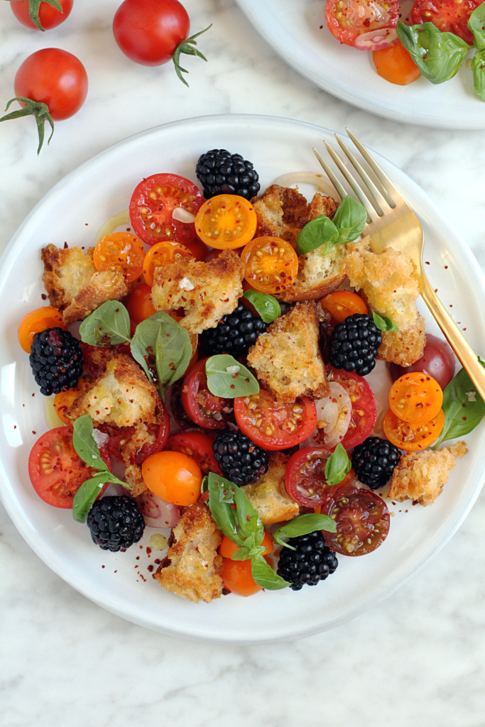 Close-up image of pickled blackberry and shallot panzanella.