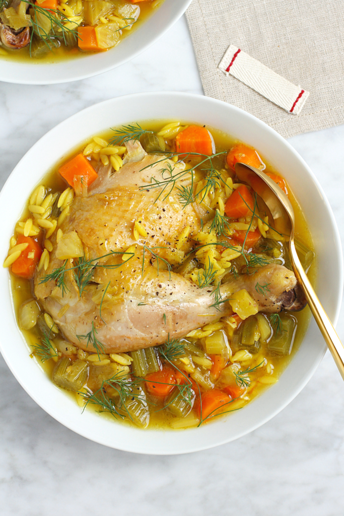 Close-up image of chicken in a pot with orzo.