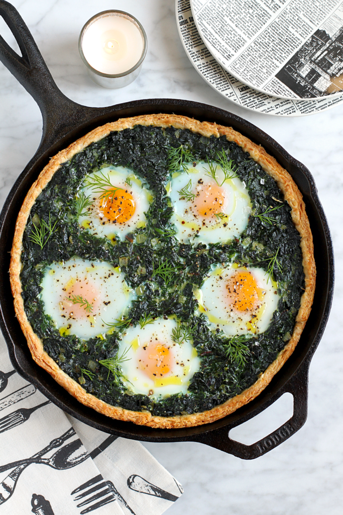 Image of creamy greens pie with baked eggs.