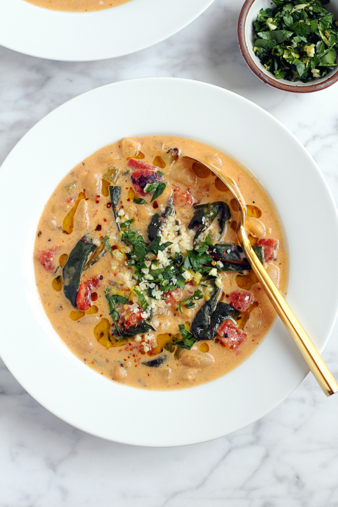 Close-up image of fire-roasted tomato and white bean soup.