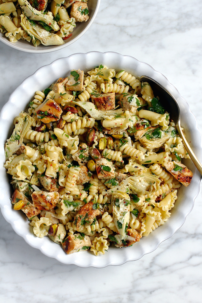 Close-up image of chicken and artichoke pasta salad.