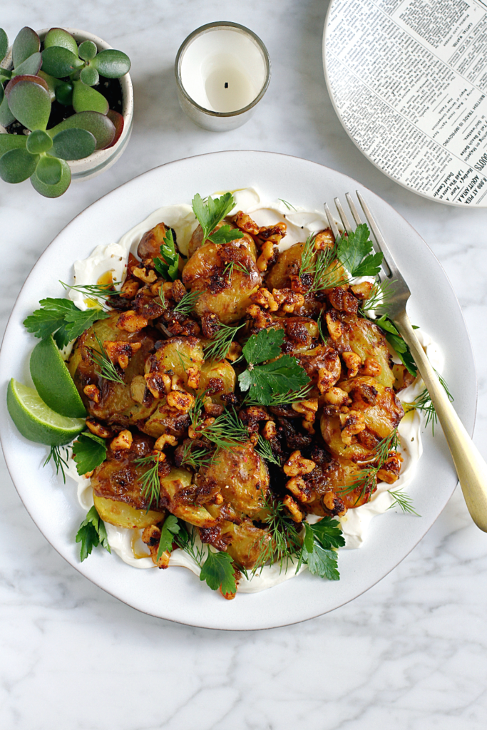 Image of crispy smashed potatoes with walnut dressing.