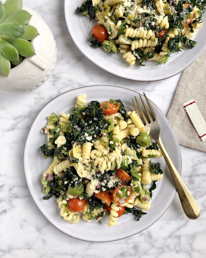 Image of plated kale pasta salad with grilled green onion vinaigrette.