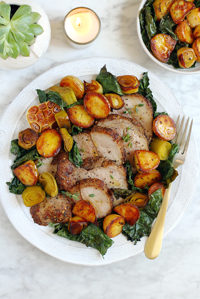 Image of roasted pork loin with potatoes and kale.