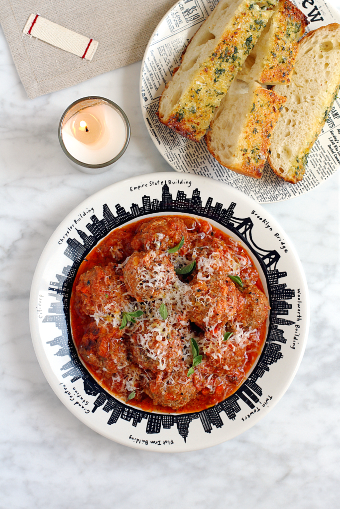 Image of beef and mortadella meatballs in tomato sauce.