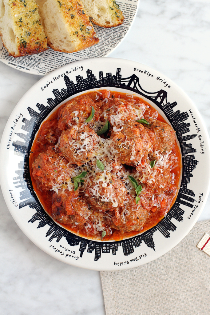 Close-up image of beef and mortadella meatballs in tomato sauce.
