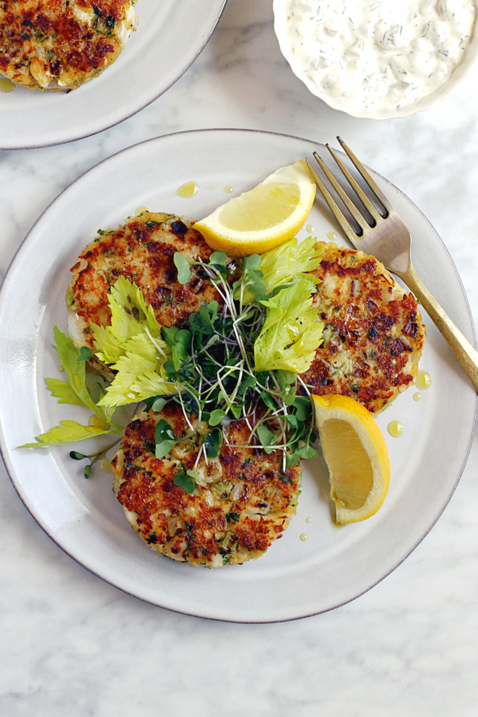 Close-up image of cod cakes with tartar sauce.